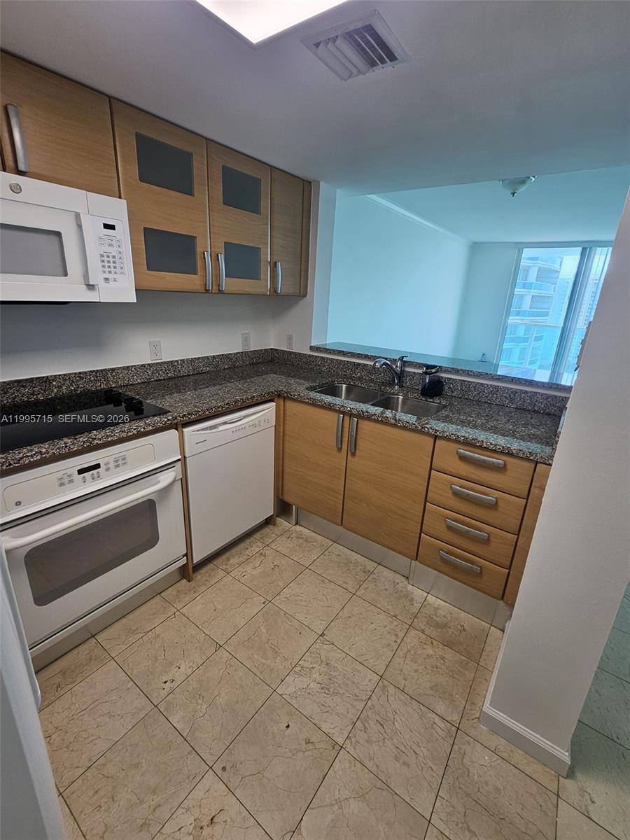 2101 Brickell Avenue, Unit 2111 Miami, FL 33129 - Photo 4 of 16 a kitchen with stainless steel appliances granite countertop a sink stove and cabinets