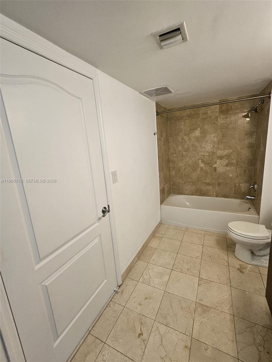 2101 Brickell Avenue, Unit 2111 Miami, FL 33129 - Photo 8 of 16 a bathroom with a granite countertop shower and a toilet