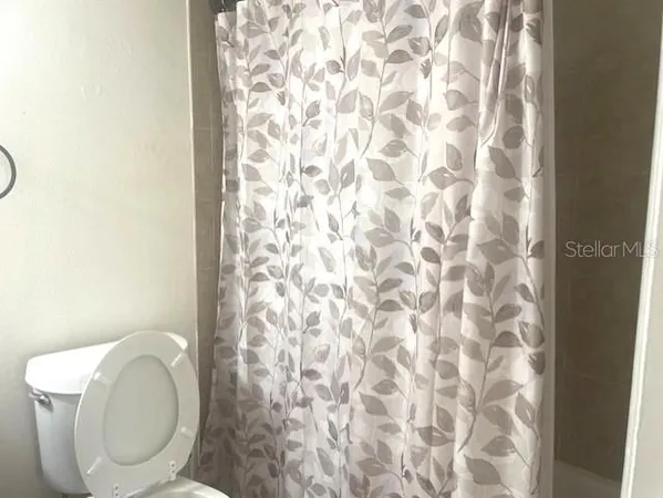 a white toilet sitting next to a shower curtain