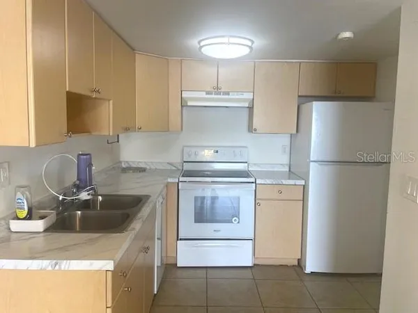 a kitchen with a sink and a refrigerator