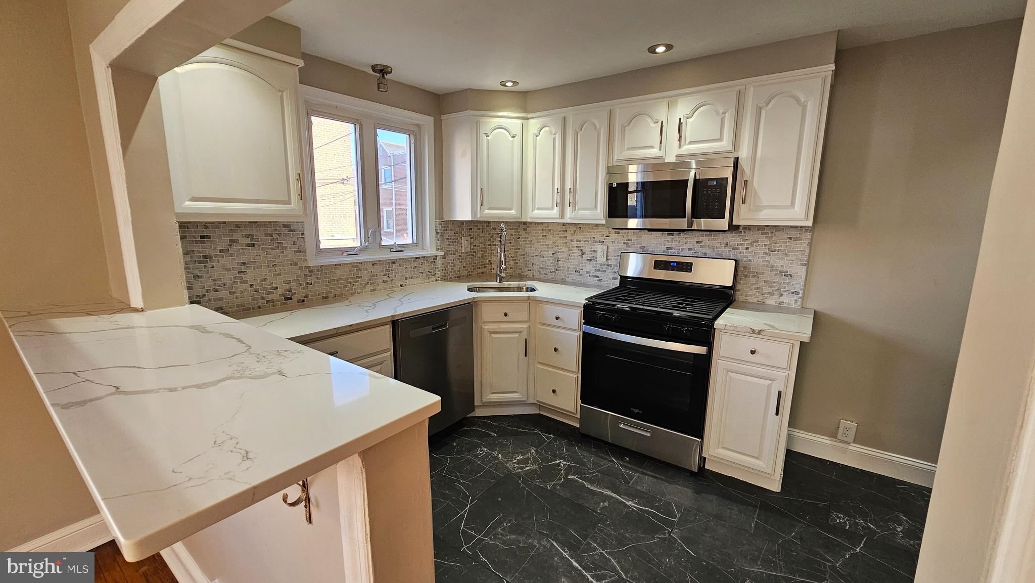 825 Laurel Road Lansdowne, PA 19050 - Photo 11 of 35 a kitchen with a sink stove and microwave
