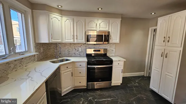 a kitchen with stainless steel appliances granite countertop a stove a sink and a refrigerator