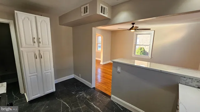 a view of hallway with window and wooden floor