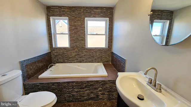 a bathroom with a toilet sink and mirror