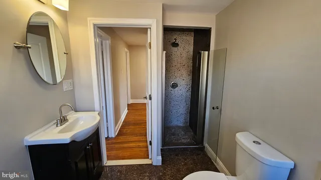 a bathroom with a sink and mirror with toilet
