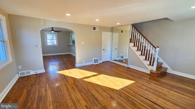 a view of a hallway with wooden floor and staircase