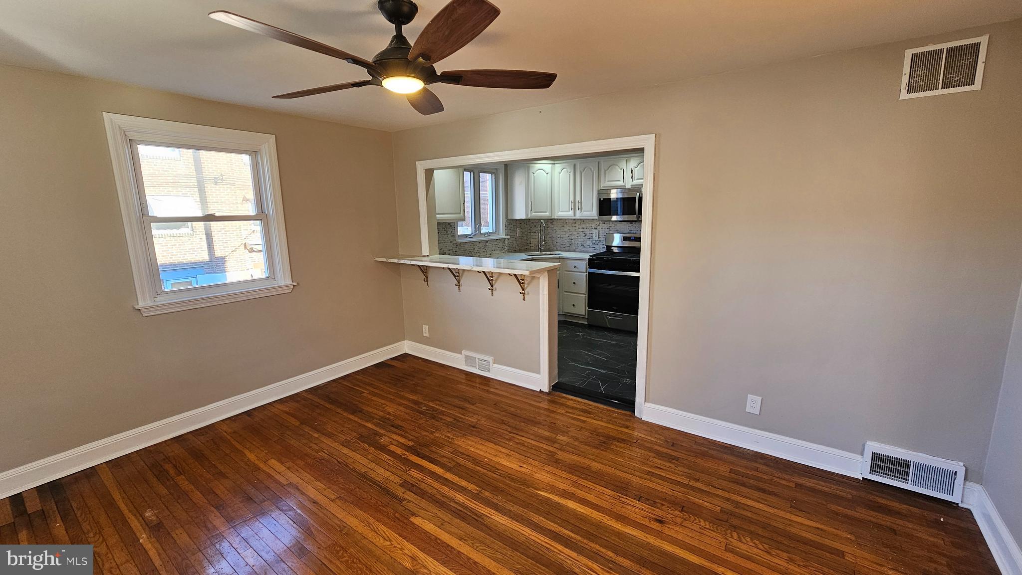 825 Laurel Road Lansdowne, PA 19050 - Photo 9 of 35 a view of an empty room with window and wooden floor
