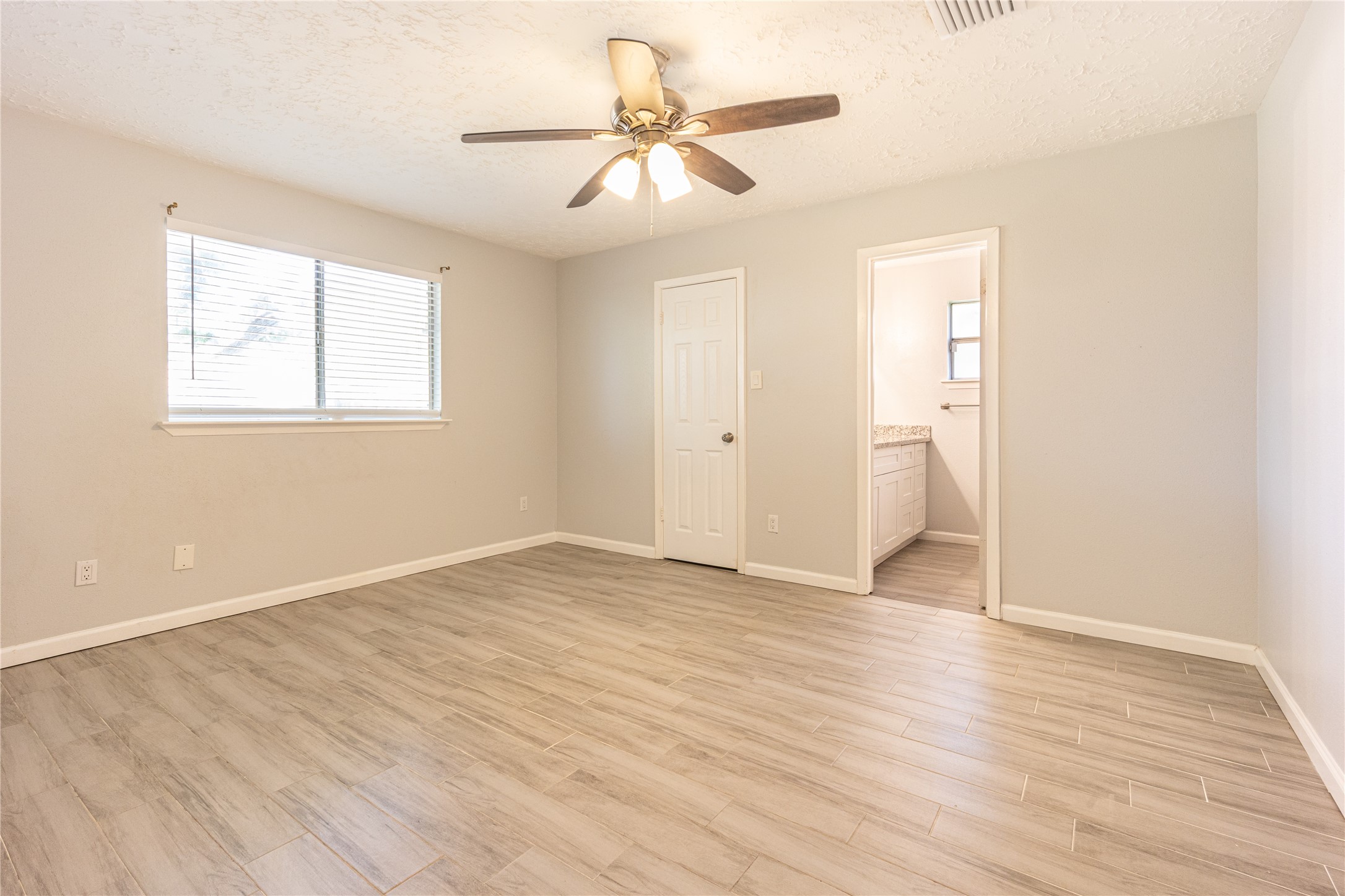 1010 Woodbridge Avenue Pearland, TX 77584 - Photo 5 of 14 an empty room with wooden floor and windows
