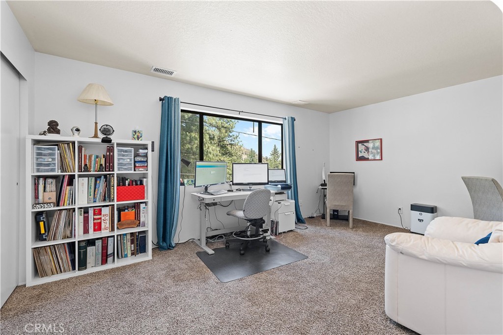 1876 Sparrow Road Wrightwood, CA 92397 - Photo 24 of 31 a living room with furniture a book shelf and a bookshelf
