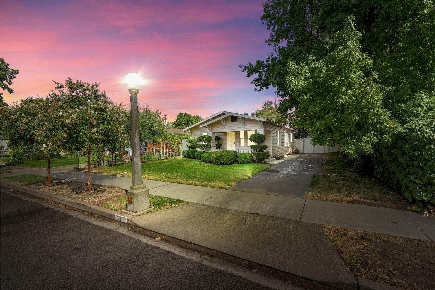 a front view of a house with a yard and trees