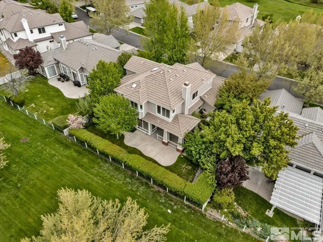 an aerial view of residential house with outdoor space and trees all around