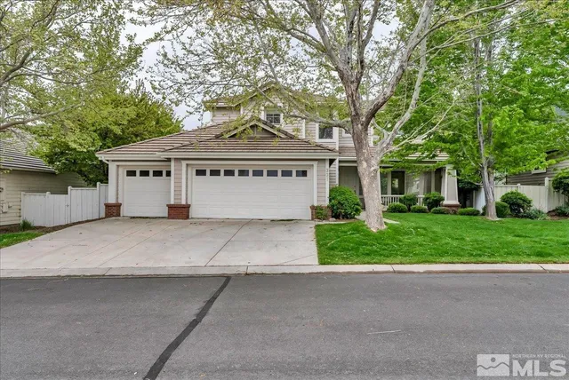 a front view of a house with a yard and trees