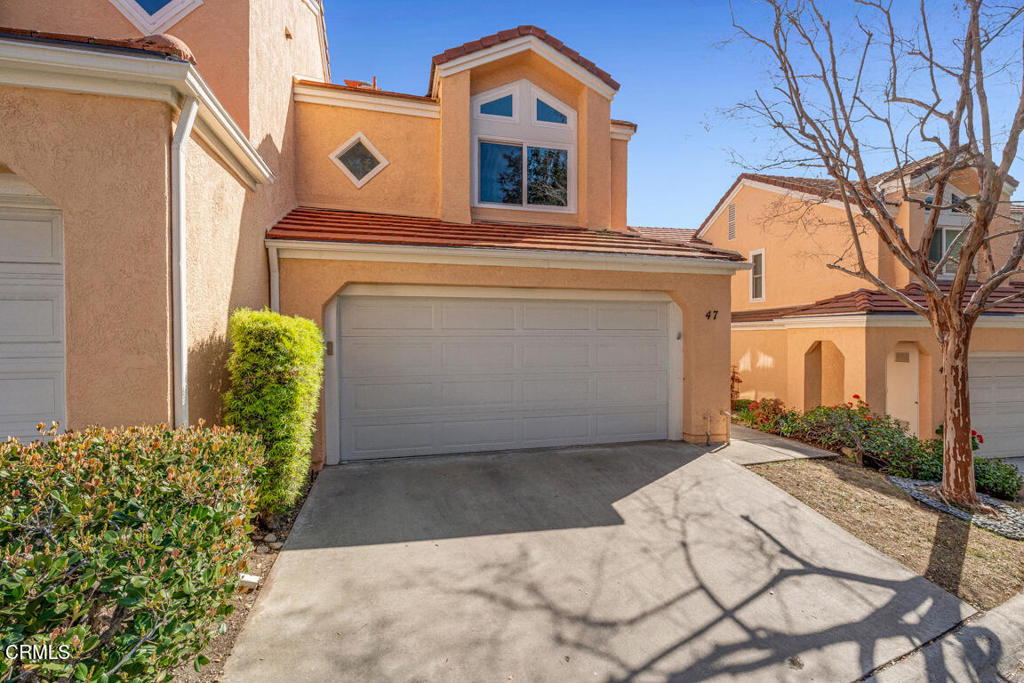 6301 Honolulu Avenue, Unit 47 Tujunga, CA 91042 - Photo 2 of 40 a front view of a house with a yard and garage