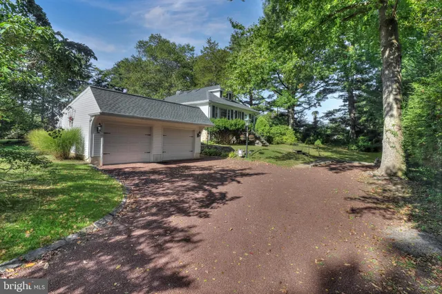 a view of a house with a yard and a large tree