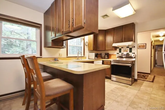 a kitchen with stainless steel appliances kitchen island granite countertop a sink and a refrigerator