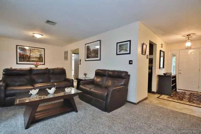 a living room with furniture a couch and paintings on the wall