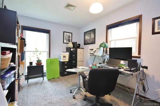 a view of a workspace with furniture and a window