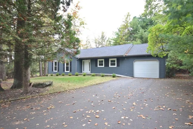 a view of a house with a yard and large tree