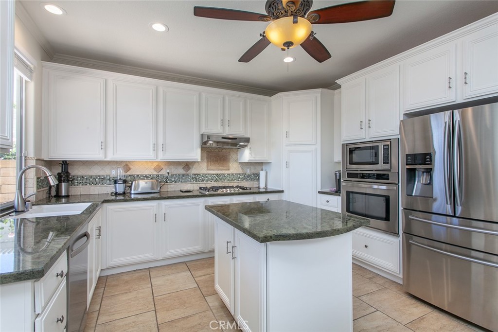 26211 Reade Place Stevenson Ranch, CA 91381 - Photo 16 of 42 a kitchen with stainless steel appliances granite countertop a sink stove and refrigerator