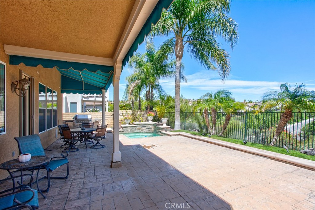 26211 Reade Place Stevenson Ranch, CA 91381 - Photo 30 of 42 a view of a patio with table and chairs potted plants and palm tree