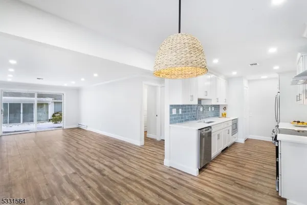 a kitchen with stainless steel appliances granite countertop a sink stove and a wooden floors