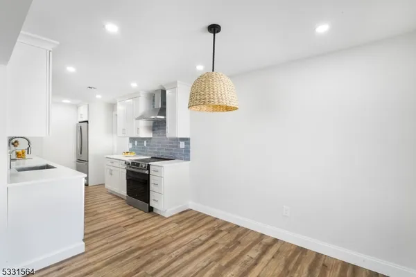 a kitchen with granite countertop a stove and a wooden floors