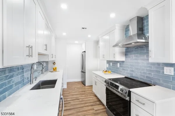 a kitchen with stainless steel appliances a stove a sink and a refrigerator
