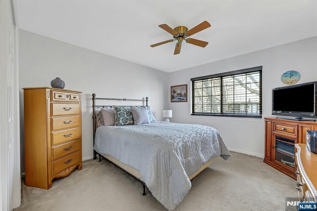 1712 Faulkner Court Mahwah, NJ 07430 - Photo 11 of 17 a bedroom with a bed a flat screen tv and a window