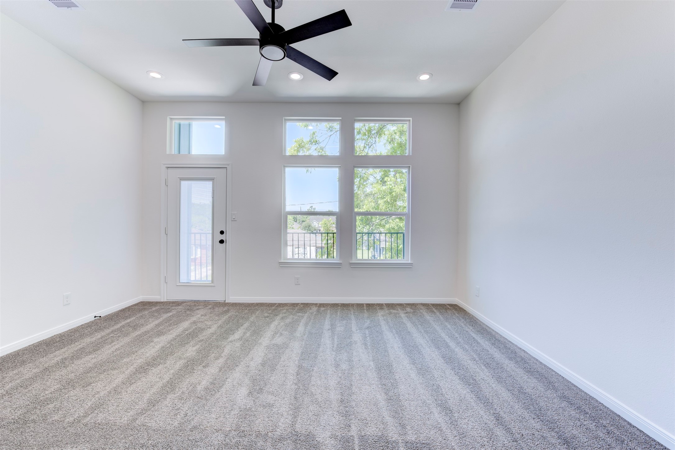 6809 Paris Street Houston, TX 77021 - Photo 27 of 37 Light-filled primary bedroom featuring a ceiling fan with integrated light, recessed lighting, and soft carpet underfoot. Enjoy direct access to a private balcony for added indoor-outdoor living.
