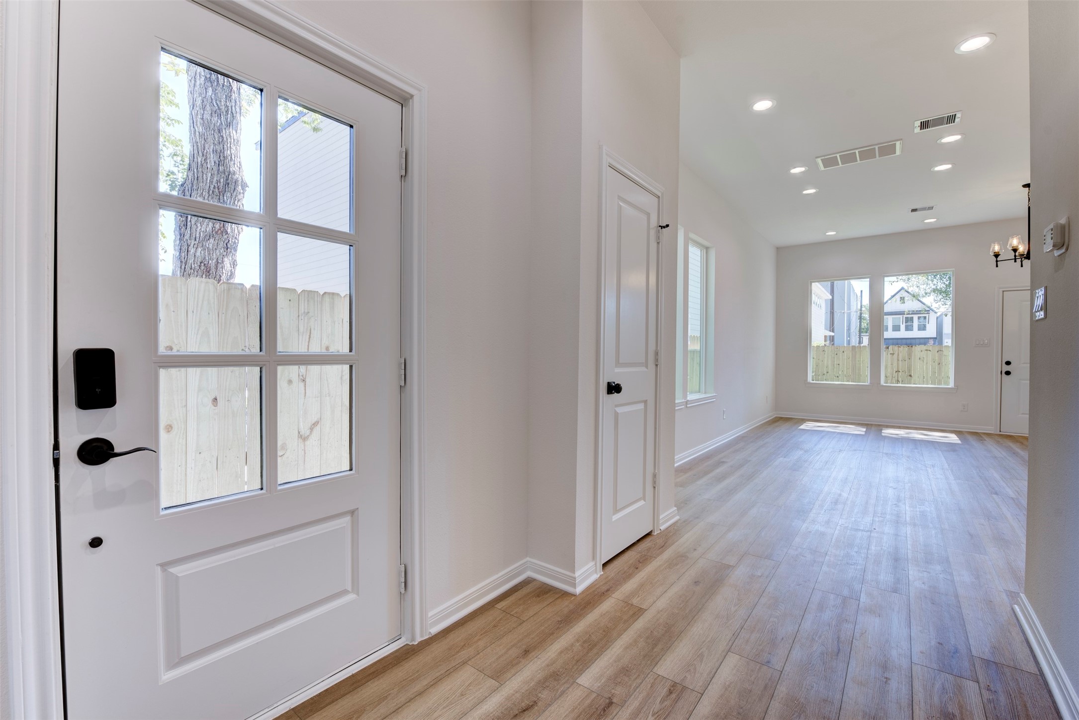 6809 Paris Street Houston, TX 77021 - Photo 3 of 37 Welcoming entry with a glass-paneled front door that brings in natural light while maintaining privacy. Wood-look LVP flooring flows throughout, paired with tall ceilings and a clean, neutral palette.
