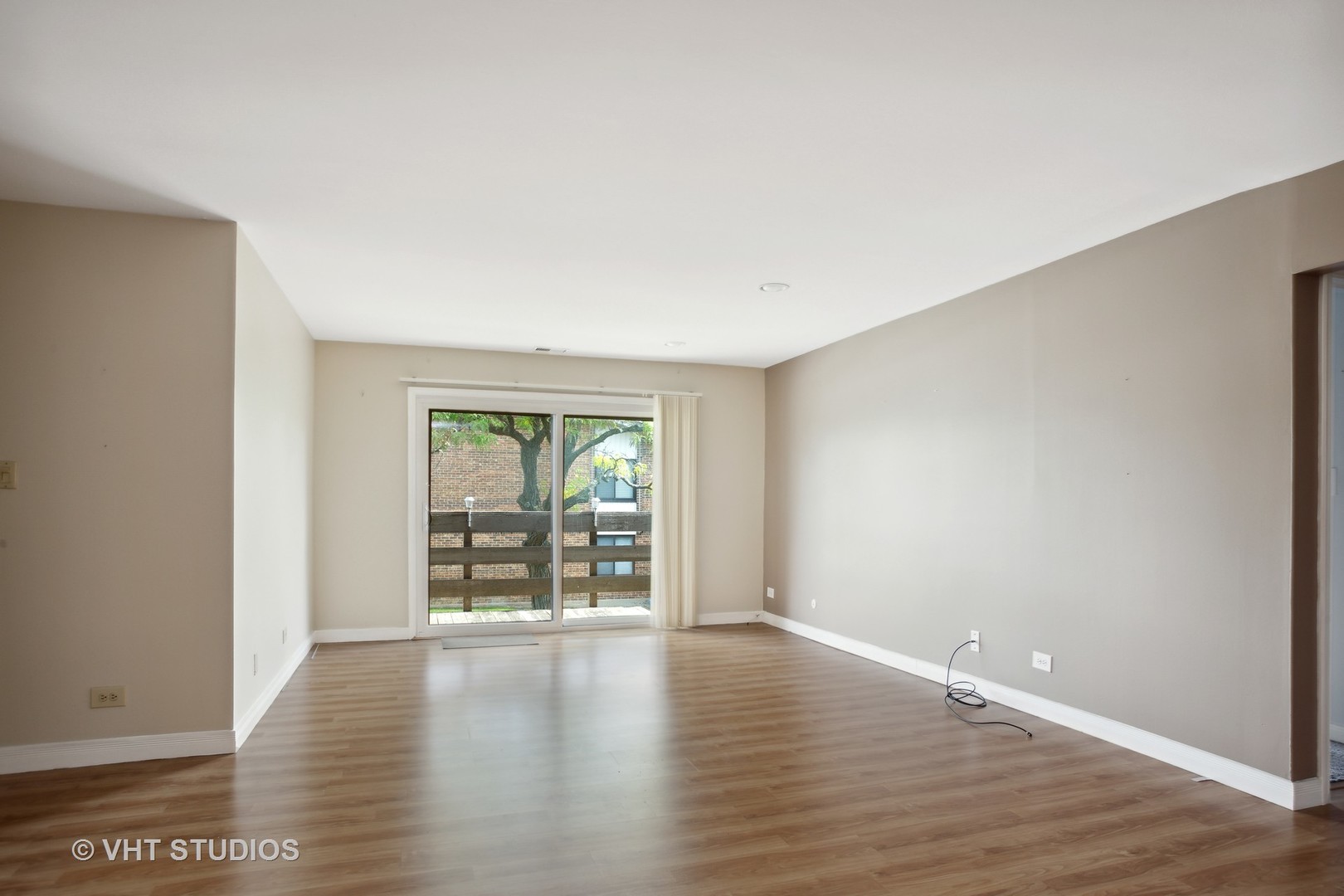 456 Raintree Court, Unit 2D Glen Ellyn, IL 60137 - Photo 2 of 10 a view of an empty room with wooden floor and a window