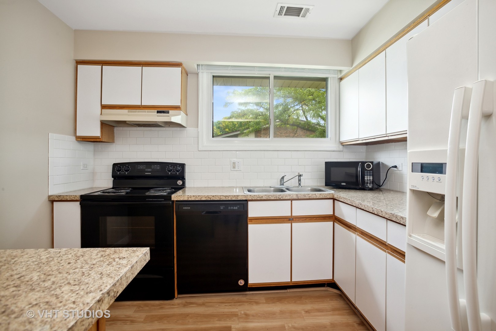 456 Raintree Court, Unit 2D Glen Ellyn, IL 60137 - Photo 4 of 10 a kitchen with a stove a sink and a window