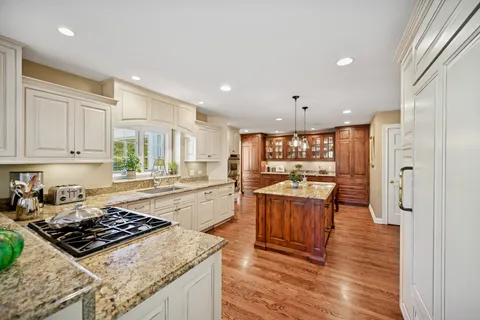 a large kitchen with stainless steel appliances granite countertop a stove and a refrigerator