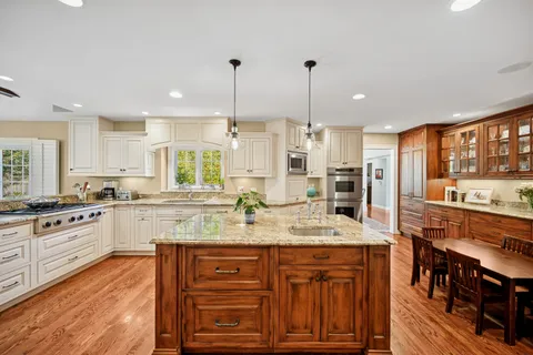 a kitchen with stainless steel appliances granite countertop a stove a sink and a refrigerator