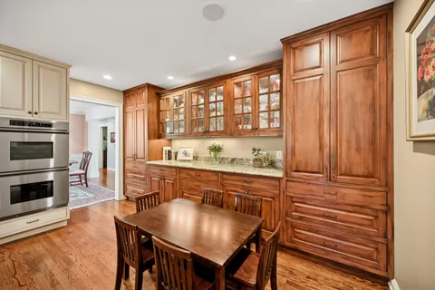 a kitchen with stainless steel appliances granite countertop a stove a refrigerator a kitchen island a table and chairs