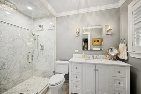 a bathroom with a sink toilet vanity and shower