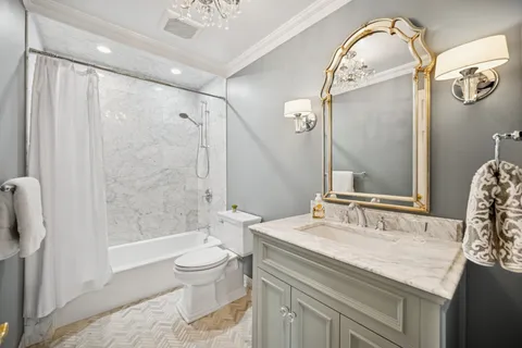 a bathroom with a granite countertop sink a toilet and shower