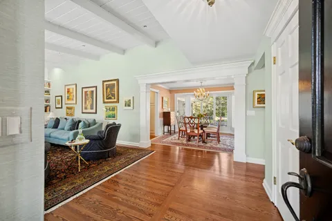 a living room with furniture a large window and wooden floor