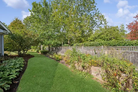 a backyard of a house with lots of green space and lake view