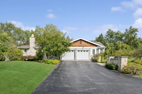 a front view of a house with a yard and trees