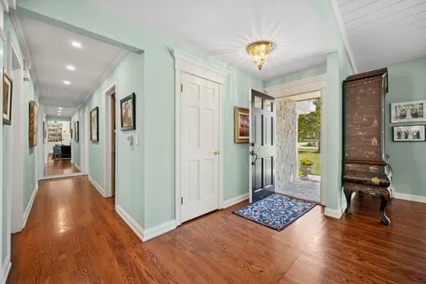 a view of a hallway with wooden floor and windows