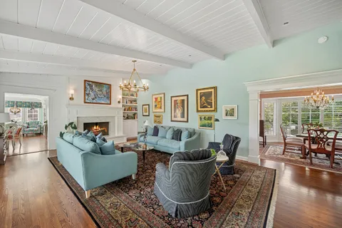 a living room with fireplace furniture and a large window