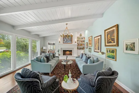 a living room with furniture fireplace and a large window