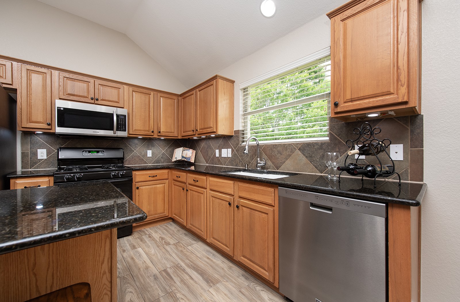 118 Chestnut Court Georgetown, TX 78633 - Photo 8 of 31 a kitchen with stainless steel appliances wooden cabinets a stove a sink and a window