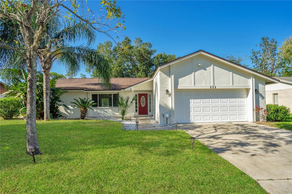 a front view of a house with a yard and garage