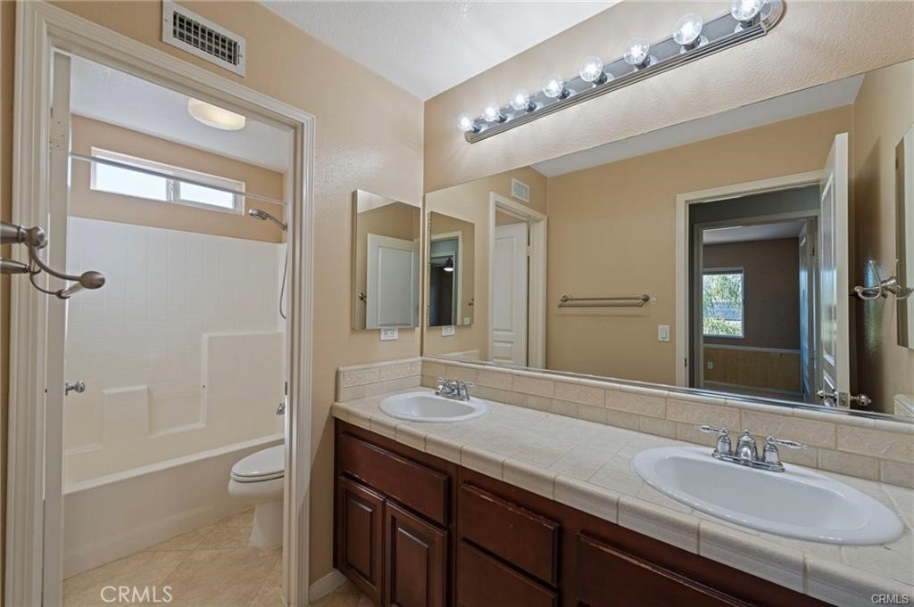 8634 Hunt Canyon Road Corona, CA 92883 - Photo 23 of 31 a bathroom with a granite countertop sink a toilet and shower