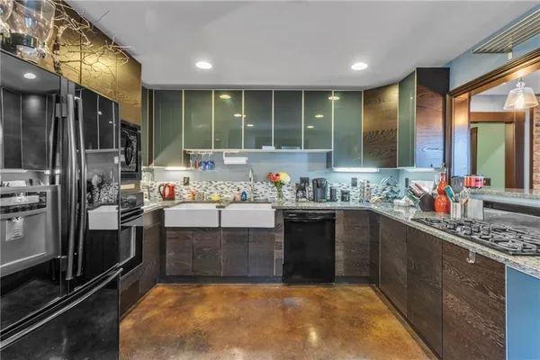 a kitchen with stainless steel appliances granite countertop a sink stove and refrigerator