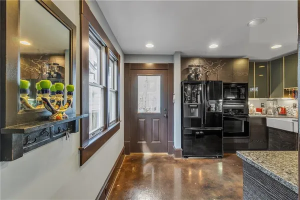 a kitchen with stainless steel appliances kitchen island granite countertop a refrigerator and stove