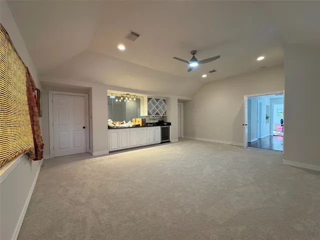 an empty room with a ceiling fan and windows