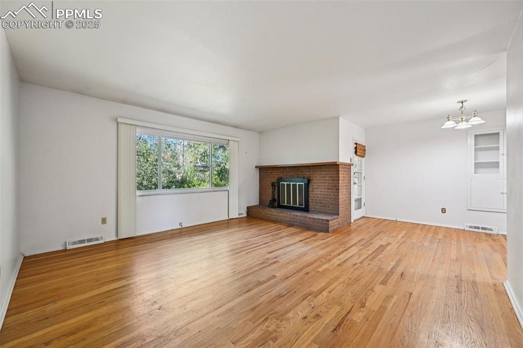 2977 South Oneida Street Denver, CO 80224 - Photo 11 of 50 a view of empty room with wooden floor and fireplace